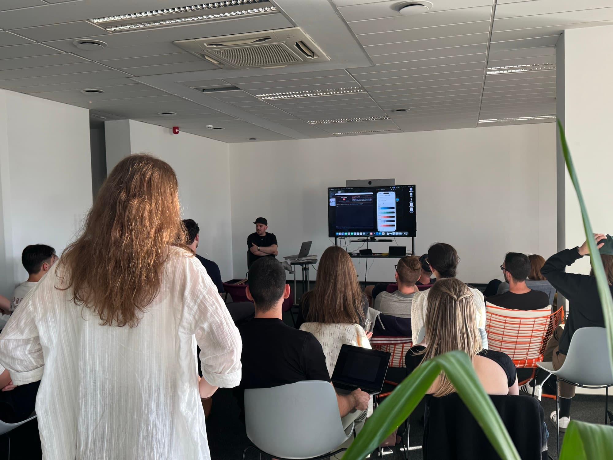 A speaker presenting to the room at a design show and tell